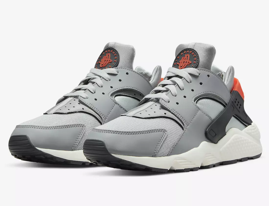 नारंगी हाइलाइट्स के साथ ग्रे रंग में Nike Air Huarache दिखाई देता है