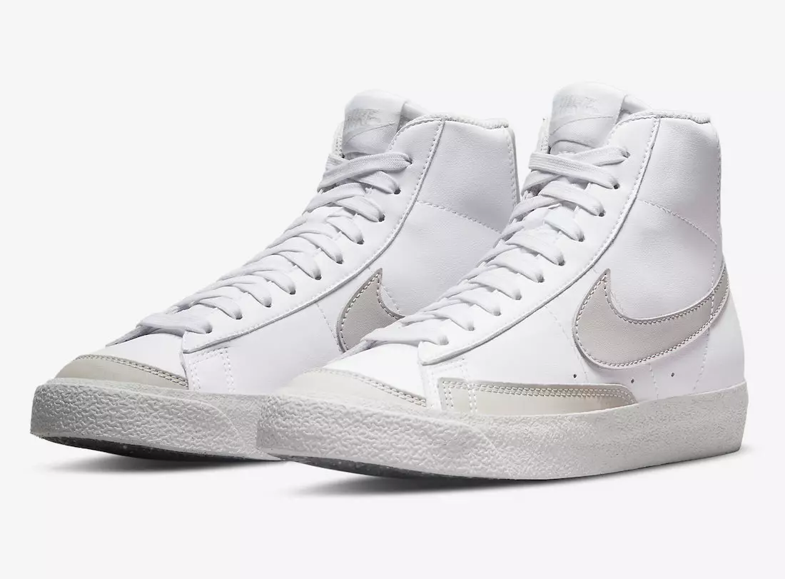 Nike Blazer Mid는 흰색과 회색으로 나타납니다.