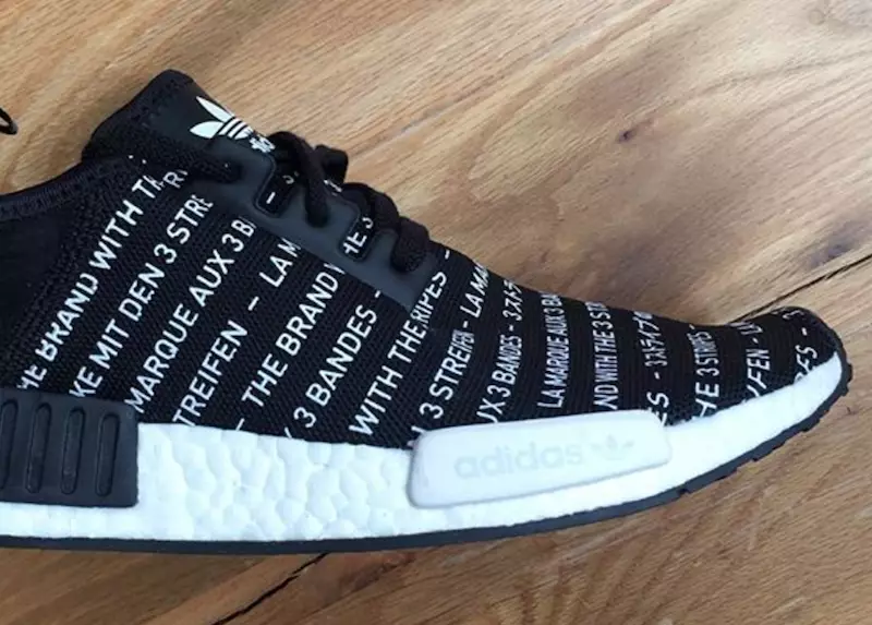 “The Brand with the 3 Stripes” ဆောင်ပုဒ်သည် ဤပုံနှိပ်ထားသော adidas NMD ကို ဖုံးလွှမ်းထားသည်။