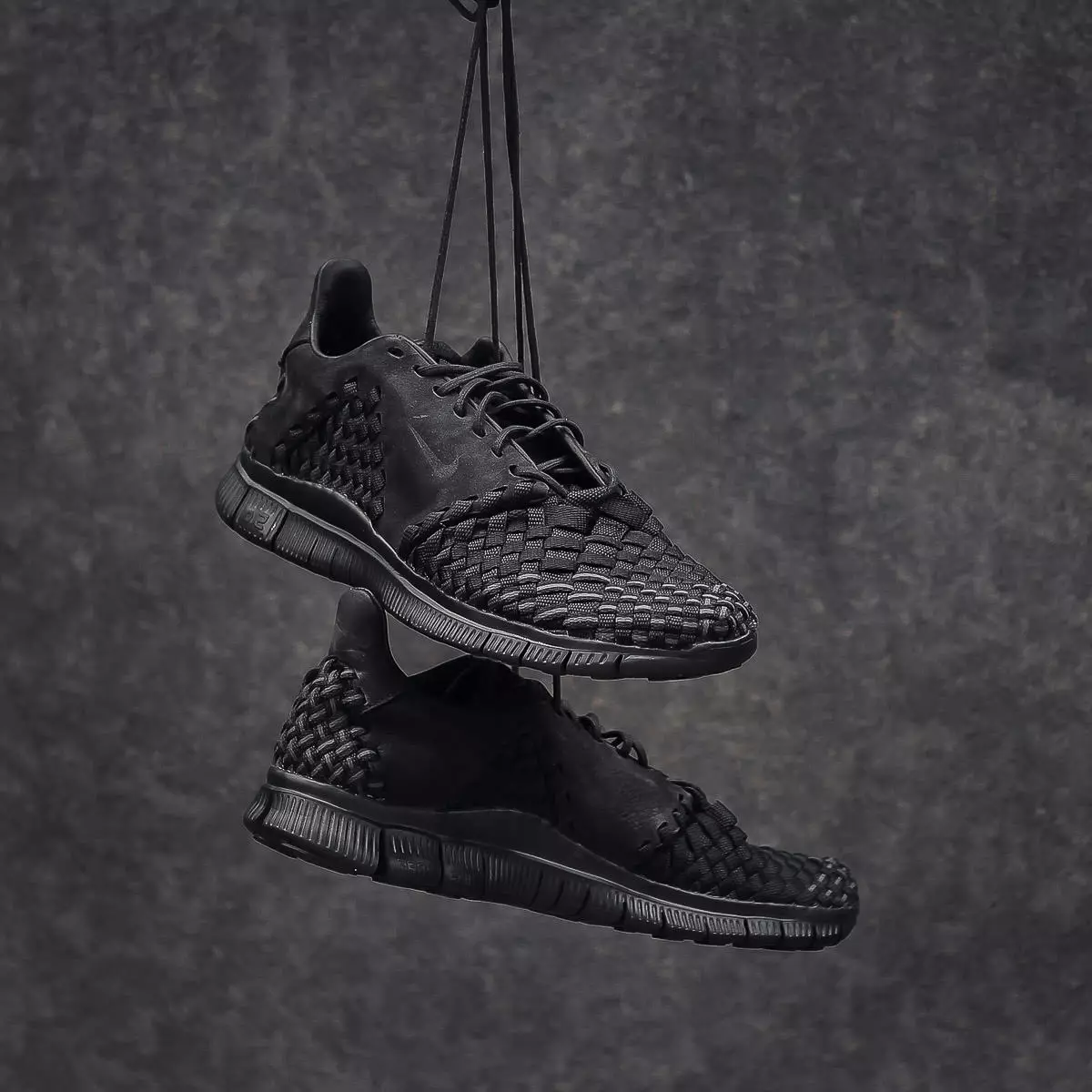 Изображения кроссовок Nike Free Inneva Woven 2 Triple Black черного цвета с фирменным плетеным верхом поверх подошвы Nike Free 5.0 полностью черного цвета.