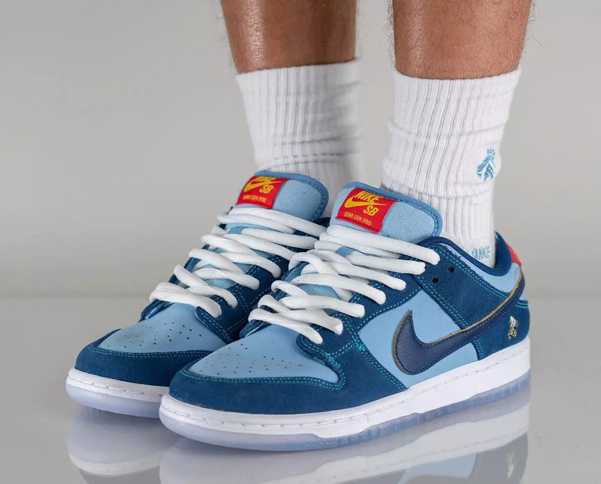 פארוואס אַזוי טרויעריק Nike SB Dunk Low DX5549-400 מעלדונג טאָג אויף די פֿיס